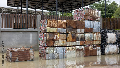Scrap aluminum cans are compressed into blocks and stacked.