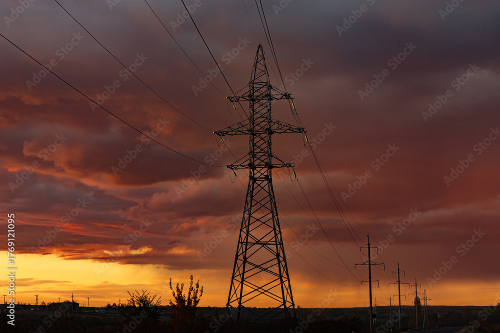 Fototapeta premium Electricity pylons at sunset. Electricity distribution station. Energy industry.