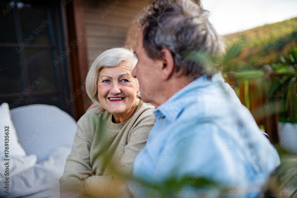 Fototapeta premium Peaceful moment for senior couple, enjoying warm autumn evening on terrace.
