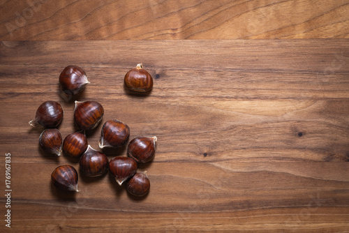 Top view of sweet chestnuts on walnut wooden board
