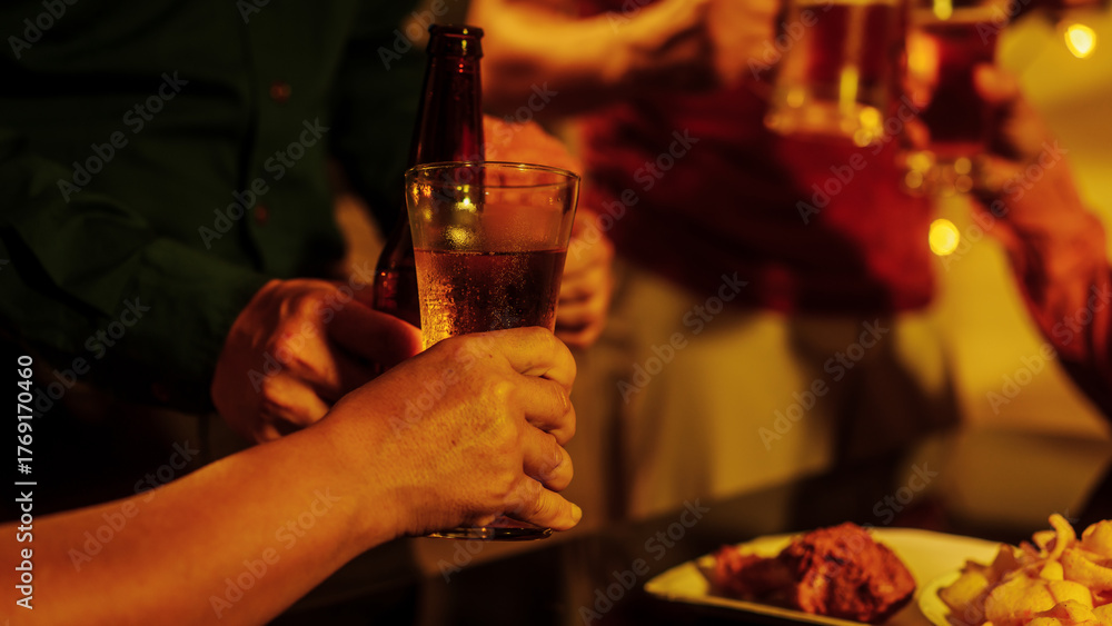 Naljepnica A group of friends toasting with beer glasses at a lively night gathering, surrounded by delicious fried chicken and snacks, symbolizing teamwork, celebration, friendship, joyful social connection
