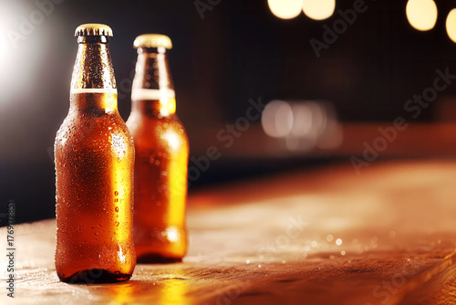 Beer bottles lined up on a bar counter, condensation dripping, happy hour specials in the background