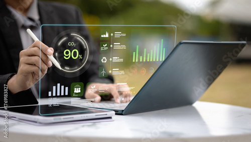 Businessman analyzing carbon footprint data on digital dashboard for sustainability management