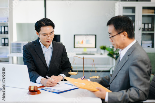 Wallpaper Mural Lawyer consulting client in modern office, reviewing documents with gavel and scales on desk. Ideal for law, finance, consulting, or corporate themes. Torontodigital.ca