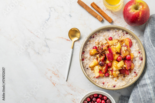 Photos Flat lay of overnight oatmeal with apple, cranberry and cinnamon in a plate on a