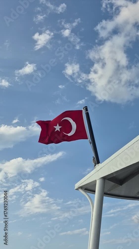 The Turkish flag standing tall and fluttering in the wind on a steamship sailing through the Bosphorus