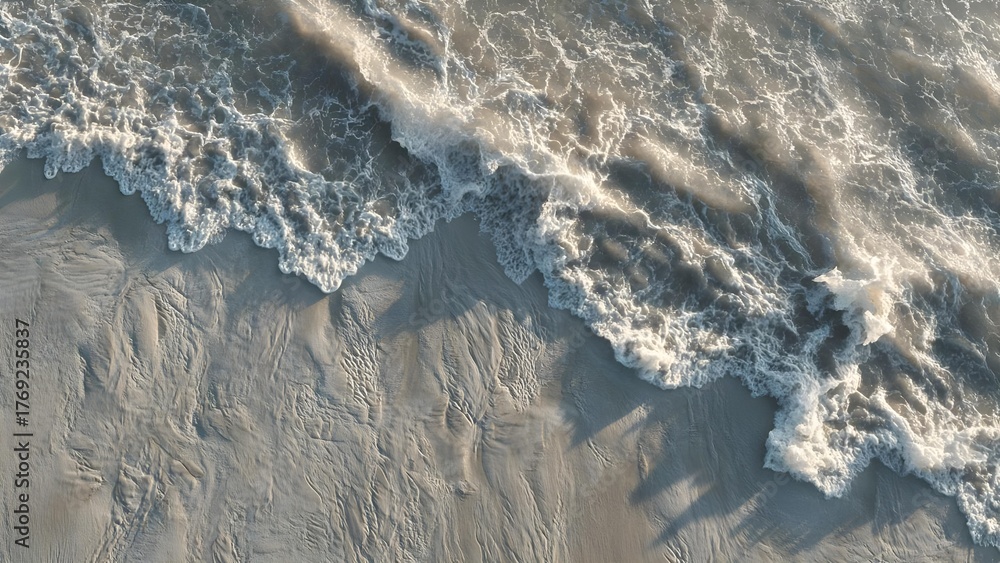Fototapeta premium Aerial view of the shoreline with foamy waves washing onto textured, rippled sand. Concept Aerial Coastal View, Foamy Waves, Textured Sand Ripples, Shoreline Photography, Oceanic Landscape