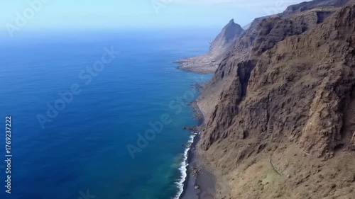 An epic landscape view of the coastline from a cliff and mountain top with the blue ocean, rocks, and sky across the horizon