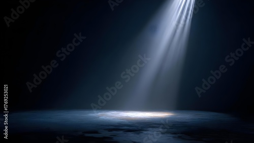 A single spotlight beams through darkness, illuminating a bright patch on a wet, reflective stage floor. Concept Spotlight, Wet reflective stage, Isolated light, Darkness and illumination