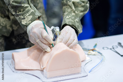 A man in military uniform conducts a master class on medical care on a mannequin