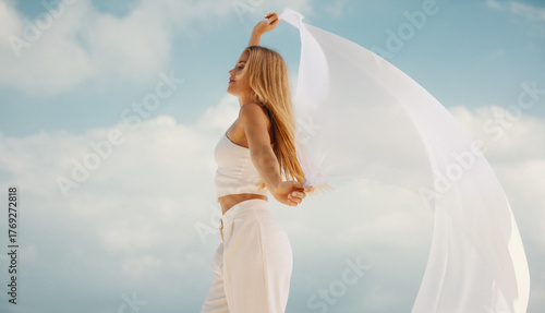 Young woman in white dancing freely under a bright sky