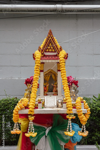 Traditional Thai Spirit House Decorated with Marigold Garlands in Bangkok, Thailand