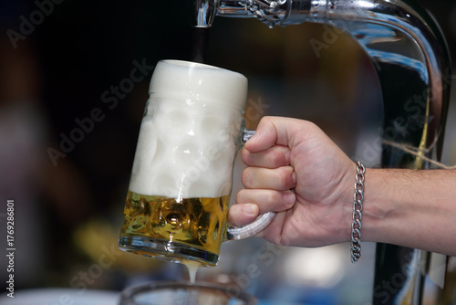 Hand Pouring Fresh Draft Beer in Glass Stein Mug from Tap