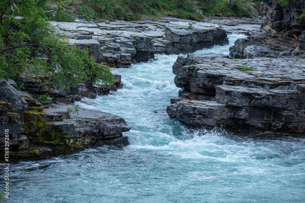 Obraz premium The turquoise water of the beautiful Abisko River, Abiskojokk, flowing between the rocks at Abisko Canyon, Sweden, Northern Europe