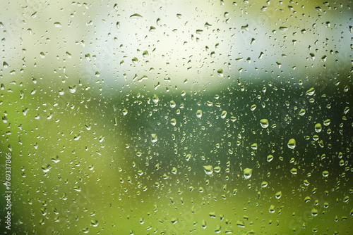 raindrops on window glass with blurred green background