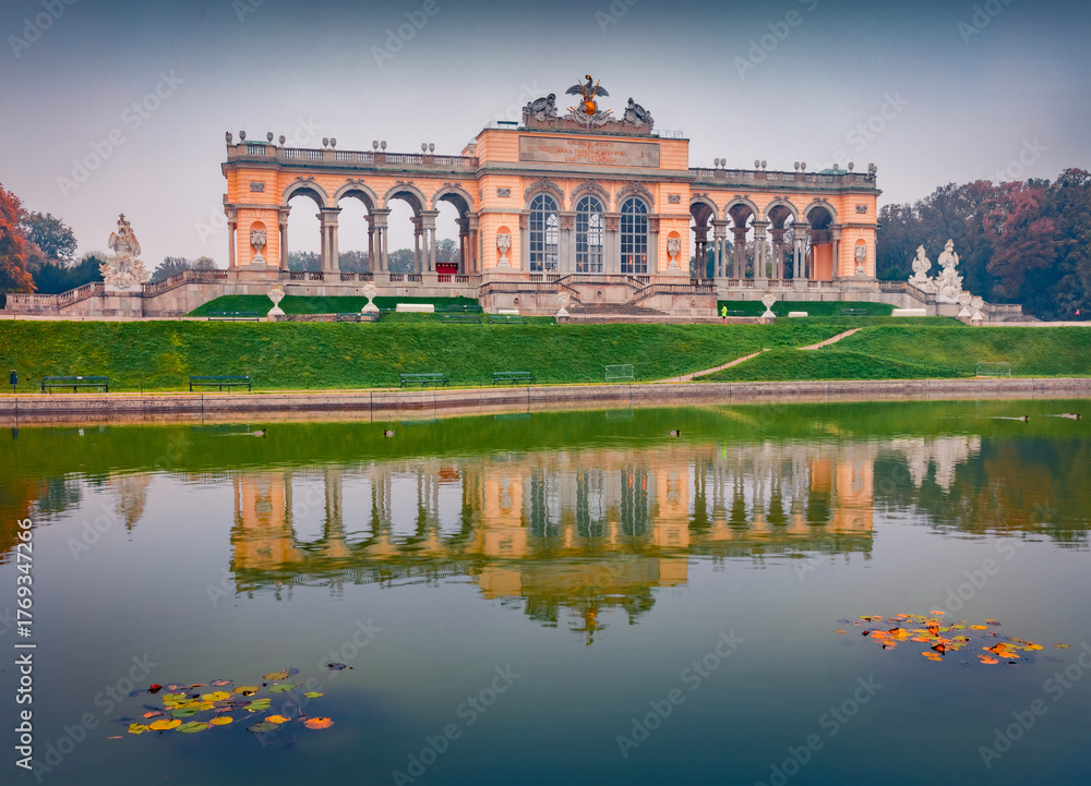 Fototapeta premium Vienna, Austria - October 27, 2024: Gloomy autumn view of historical landmark - Gloriette Schonbrunn. Beautiful morning scene of Schonbrunn Palace Park.