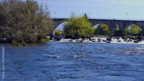 Ponte da Barca and the old Roman bridge over the Lima river, view over the rapids.