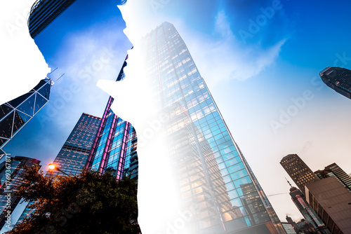 Double exposure creates a visual of a business person in Hong Kong. Skyscrapers dominate the scene, representing the city's business district.