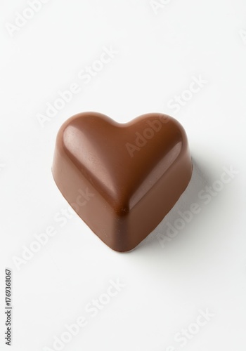 Isolated delicious milk chocolate heart shaped candy on a pure white surface, ideal for sweetness, love, romance, and dessert concepts ,brown ,simple ,affection