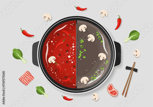 Top-down view of a traditional Asian hot pot with two distinct broths, surrounded by fresh ingredients like chilies, mushrooms, bok choy, and raw meat slices, ready for cooking.
