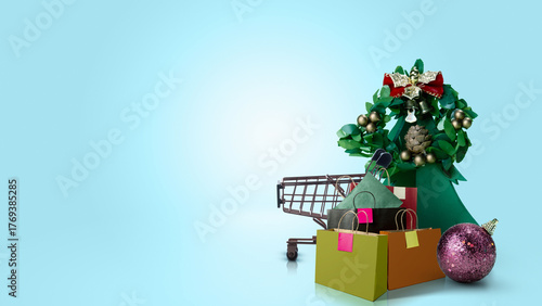Shopping cart and shopping bag with Christmas tree ornament on colored background. Copy space. Christmas sale concept