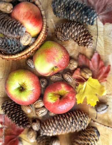 top view on bright red apples, walnuts and autumnal leaf on wooden background...