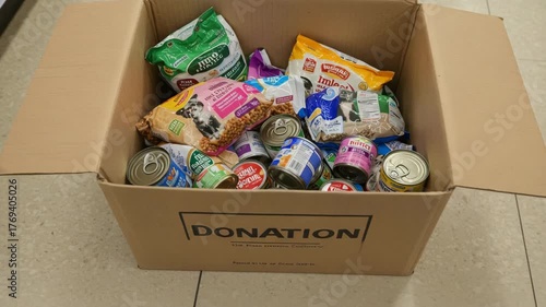 Donation box with canned pet food, dry kibble and toys for animals, donation placed near shelter entrance, donation related to charity, pet rescue, nonprofit aid and animal welfare projects