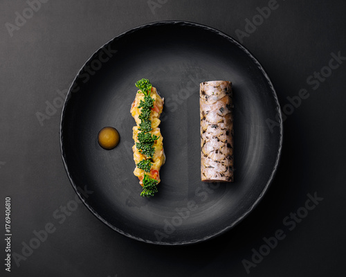 Gourmet sushi dish presented on a black plate with colorful ingredients