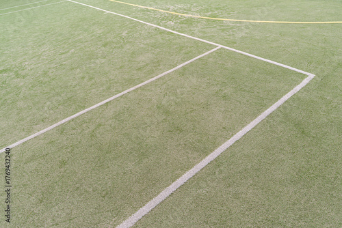 Artificial green turf with white painted lines on a open sports field