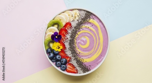 Smoothie bowl with fruits and seeds on pastel background
