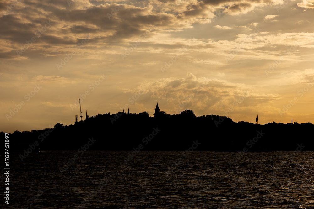 Fototapeta premium Dramatic Istanbul skyline silhouette with mosque minarets and domes at golden sunset