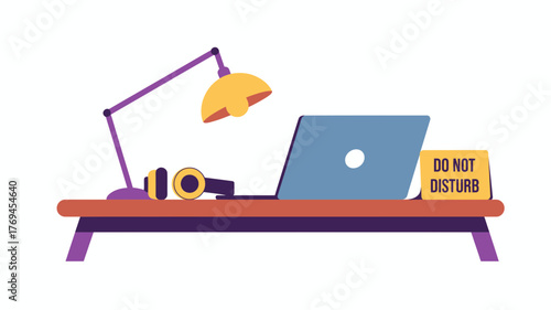 A modern desk setup with a laptop headphones and a do not disturb sign for focused work and concentration