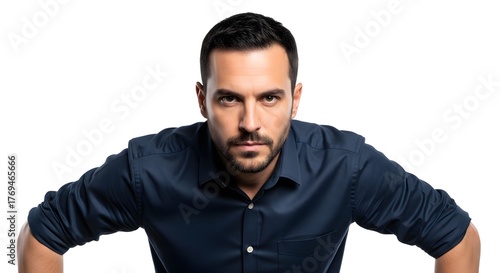 Serious man leaning forward with intense eyes, wearing a dark blue shirt against a white background, showing focus and determination.