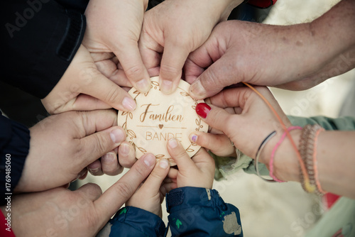 Hände halten Holzschild „Familie“ – Symbol für Zusammenhalt und Liebe