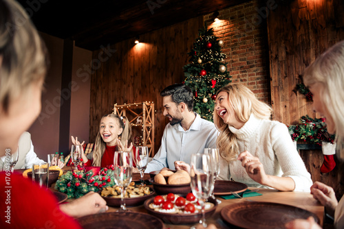 Foto Family celebration at a Christmas dinner around a festive table with a decorated