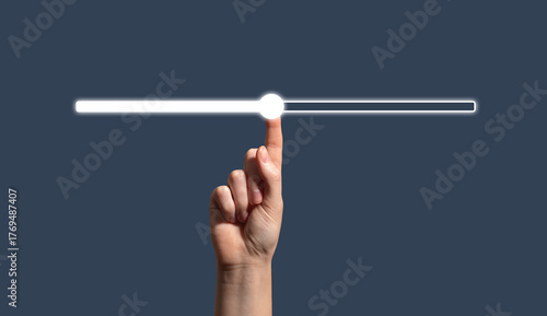Canvas Print human hand touching a glowing progress bar or slider on a dark background