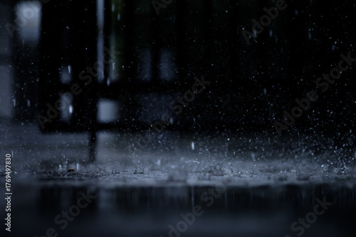 heavy raining make many small splash crown from water droplets drop down to the concrete floor in blue tone color scene