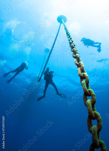 Wallpaper Mural Group of silhouettes of divers at a safety stop at the anchor chain under a boat in the sea. Torontodigital.ca