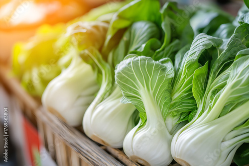 A vibrant close-up shot of fresh green bok choy (Chinese cabbage) displayed in a market or kitchen.