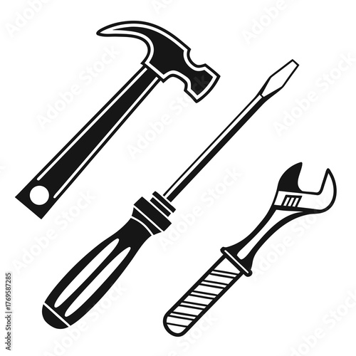 A classic set of three essential hand tools including a claw hammer a flathead screwdriver and an adjustable wrench isolated on white