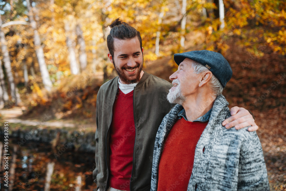 Fototapeta premium Senior father and his son walking in nature, talking.