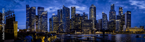Aerial view of city lights twinkle against the inky sky, reflecting on the water near Marina Bay Sands, Singapore, Singapore.