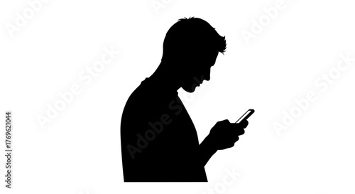 Silhouette of a man looking at his mobile phone in darkness