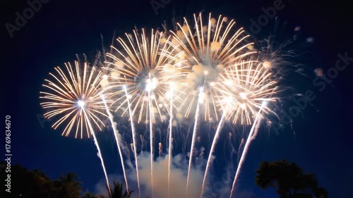Vibrant golden chrysanthemum fireworks explode against a deep twilight sky with streaks of white