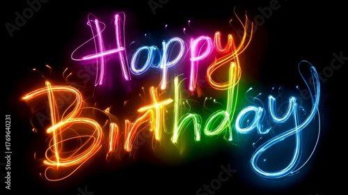 Glowing happy birthday text written with vibrant rainbow light painting on a deep black background for celebration graphics.