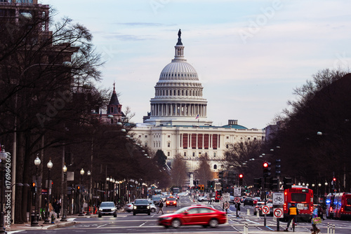 View of the United States Capitol Building stands majestically at the end of a busy street bustling with cars and buses, Washington, District of Columbia, United States.