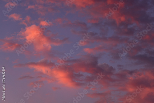 Vibrant sunset sky with soft pink and purple clouds creating a dreamy, colorful and peaceful background.