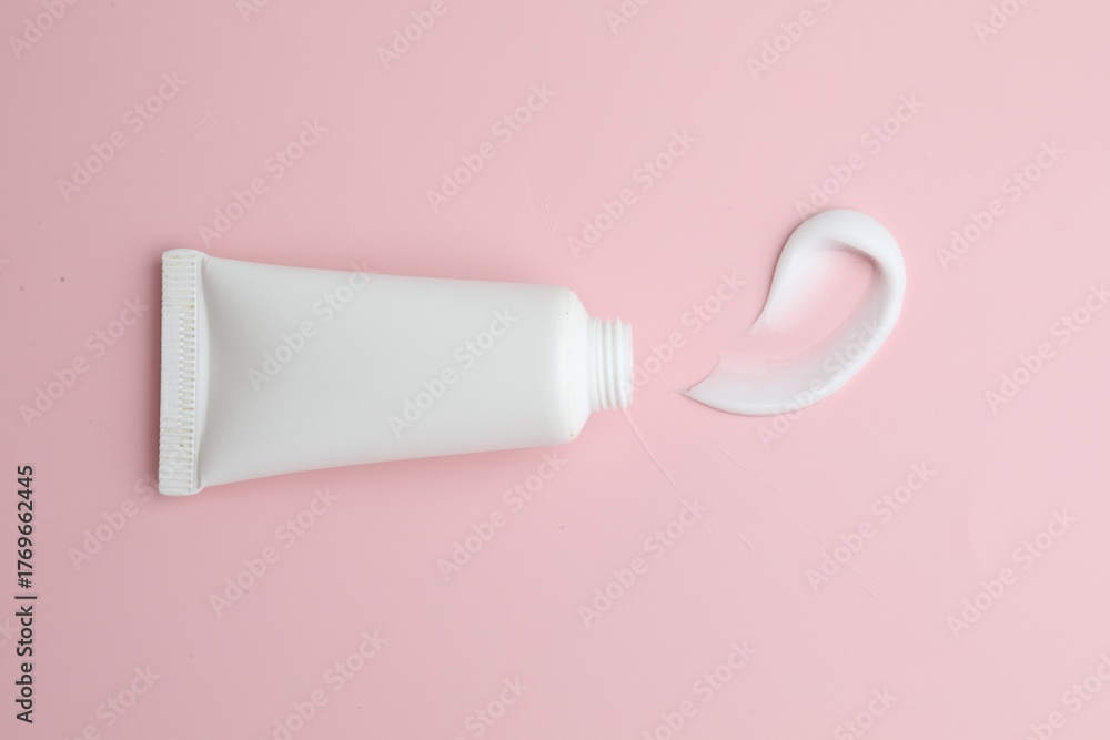 Obraz premium Sample of moisturizing cream and tube on pink background, top view