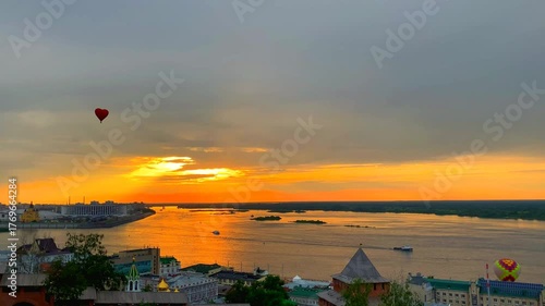 NIZHNY NOVGOROD, RUSSIA - JUNE 10, 2024: View from the Kremlin at hot air balloons. The confluence of Oka and Volga rivers, the Strelka, Alexander Nevsky Cathedral and the Stadium in the background