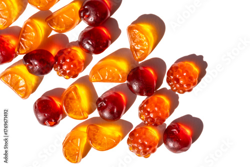 Flat lay of fruit gummies vitamins on bright white background, harsh sunlight and selective focus create strong shadows, minimalist snack composition for healthy eating concepts.